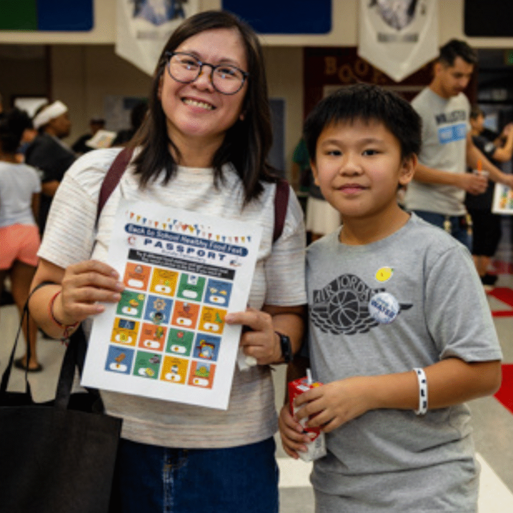 A male student and his parent hold an event passport.