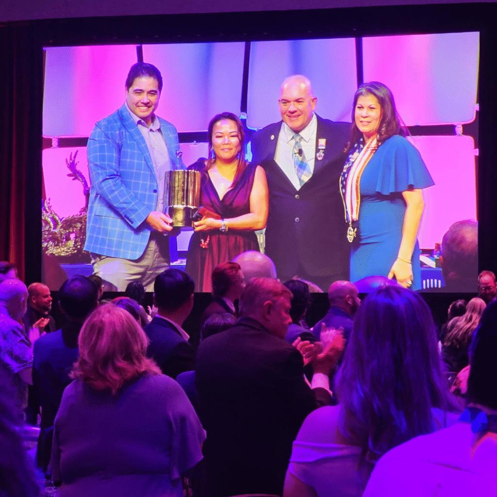 Mary Ann and Marc Ty receive an award on a screen. 